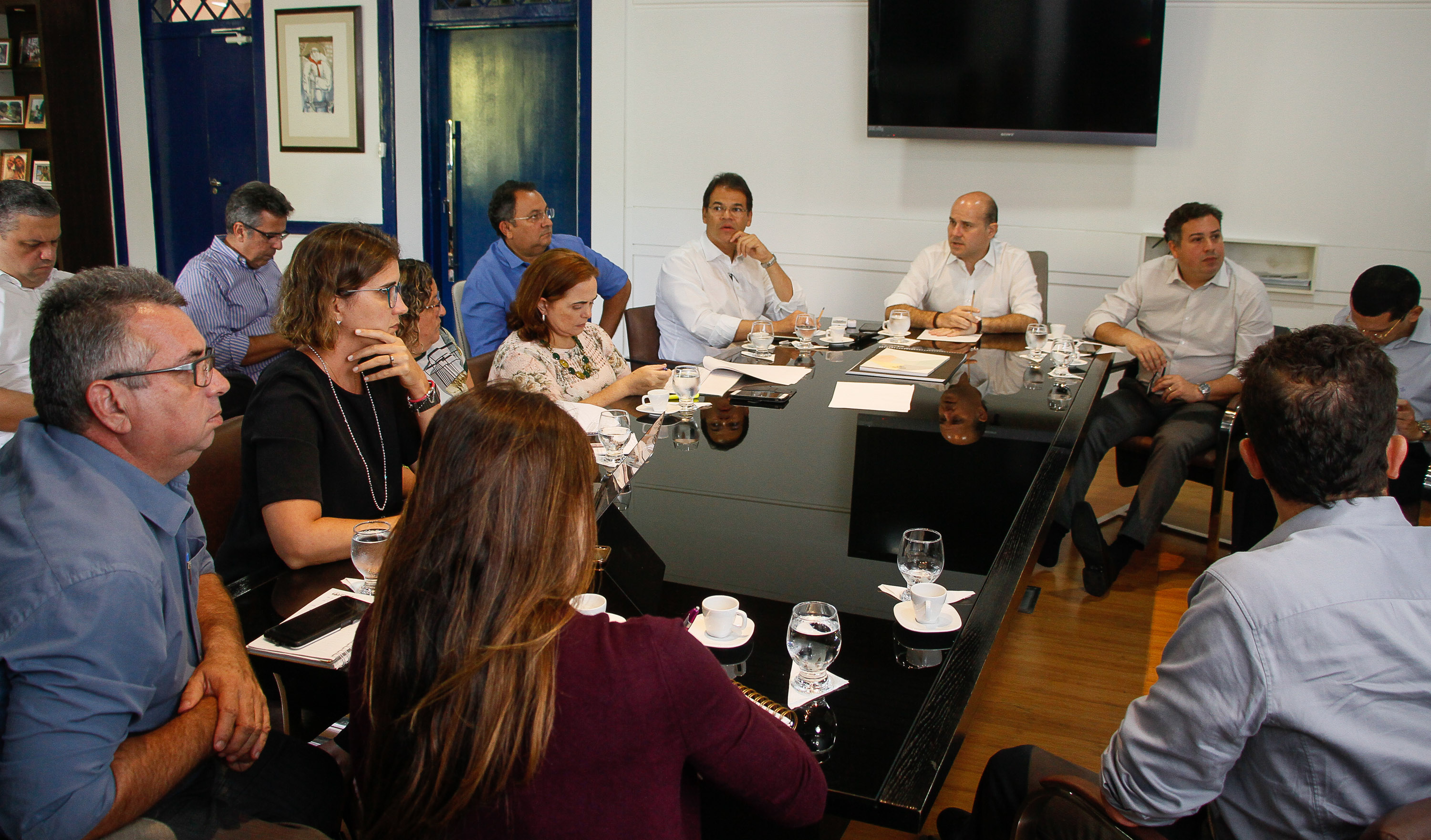 prefeito e outras pessoas sentadas ao redor de mesa conversando